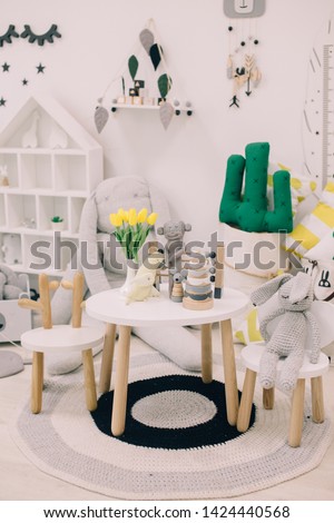 Creative playroom interior decorated with colorful lamps, cactus pillow