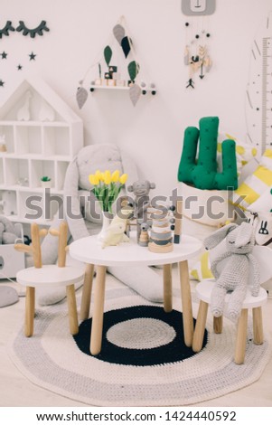 Creative playroom interior decorated with colorful lamps, cactus pillow
