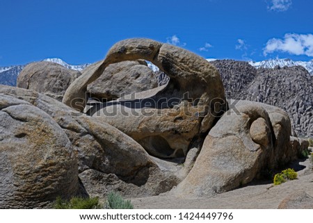 Mobius Arch in Alabama Hills,  Lone Pines in South California with snowed Mountain Whitney on the back on a summer day with blue sky