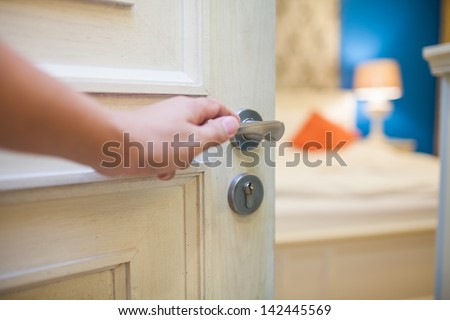 half-open door of a bedroom with hand Royalty-Free Stock Photo #142445569