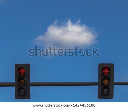 Lone Cloud Floating in the Blue Sky Above a Traffic Stop Light