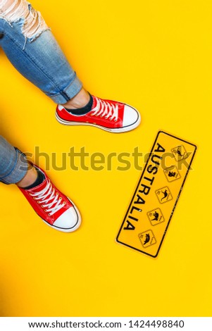 Local Australian road sign - warning of platypus and kangaroo at the feet of young man on yellow background