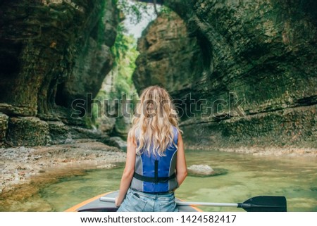 girl blond hair in boat lake Georgia Martvili Canyon, active leisure tourists, gorgeous bright wild green nature tourist rafting entertainment water, silhouette woman photo back turned away rear view