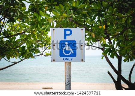 Old handicapped parking sign with picture of wheelchair on beach, Disabled reserved area