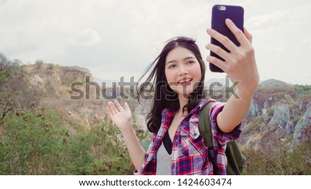 Blogger Asian backpacker woman record vlog video on top of mountain, young female happy using mobile phone make vlog video enjoy holidays on hiking adventure. Lifestyle women travel and relax concept. Royalty-Free Stock Photo #1424603474