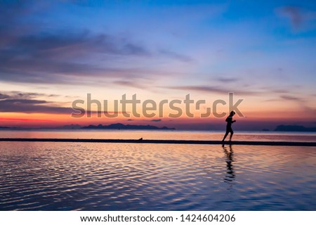 Silhouette Man running on the beach at sunset  soft focus. Sport man running at seaside with twilight  sunset