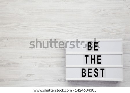 Modern board with 'Be the best' words on a white wooden surface. Flat lay, overhead, top view, from above. Copy space.