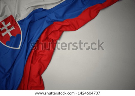 waving colorful national flag of slovakia on a gray background.