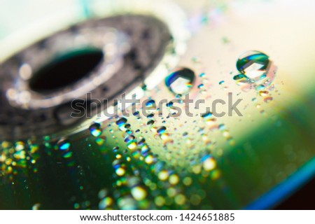 Compact disc in the background and close-up raindrops
