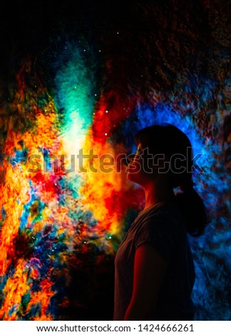 Design material - silhouette of girl stand alone in abstract universe galaxy texture background with dark blue, orange, blue color, like stars light with bokeh effect