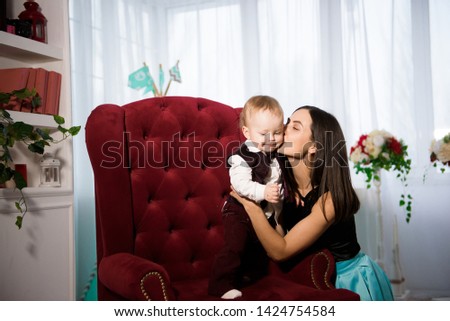 Mom and her toddler son plays in their cosy living room