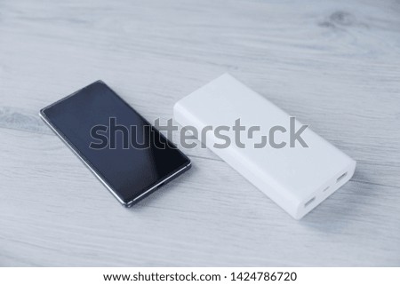 Portable Power Bank. The phone is charging with Power bank.