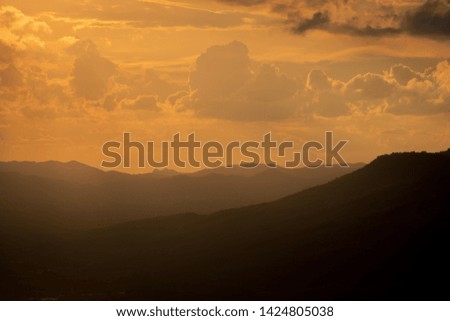 beautiful mountain view and sunset with cloudy golden sky. Panoramic view on the overlapping mountains at golden light sunset in thailand