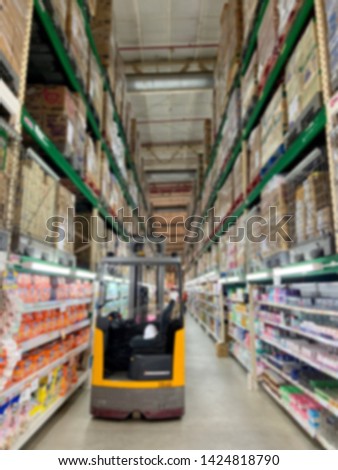 Abstract blurred supermarket aisle with shelves of consumer goods, products in grocery shop background.