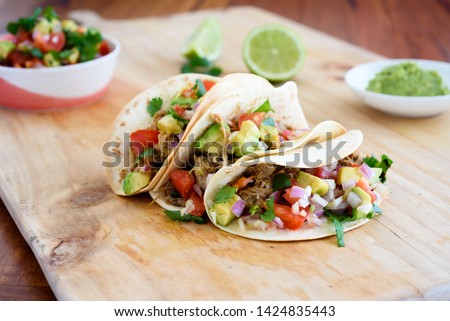 Pulled pork tacos with salsa, guacamole and lime, with copy space