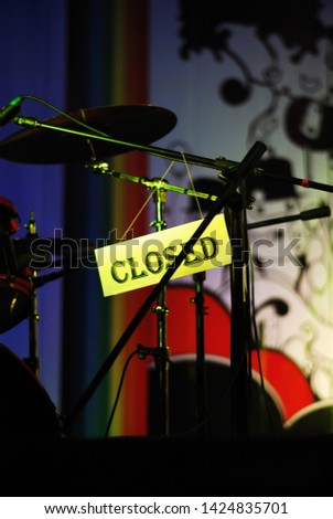 The label "closed" is hanging on the stage at the microphone stand on a dark background