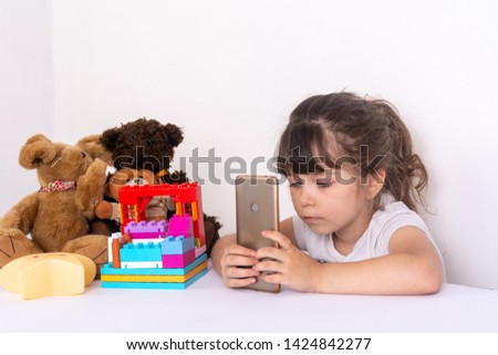 Kid spending too much time online and surfing internet on electronic tablet. Child entertaining with phones apps, family gadget addiction concept.