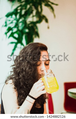 Girl having a juice in a restaurant.