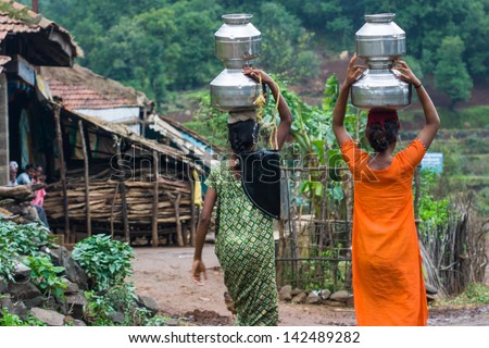Villagers carry water in a remote part of India Royalty-Free Stock Photo #142489282