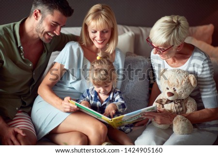 Little girl in happy family looking picture book