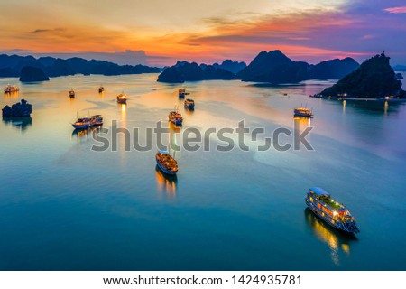 Aerial view of sunset and dawn near rock island, Halong Bay, Vietnam, Southeast Asia. UNESCO World Heritage Site. Junk boat cruise to Ha Long Bay. Popular landmark, famous destination of Vietnam Royalty-Free Stock Photo #1424935781