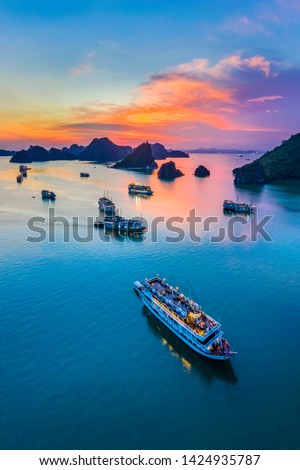 Aerial view of sunset and dawn near rock island, Halong Bay, Vietnam, Southeast Asia. UNESCO World Heritage Site. Junk boat cruise to Ha Long Bay. Popular landmark, famous destination of Vietnam Royalty-Free Stock Photo #1424935787