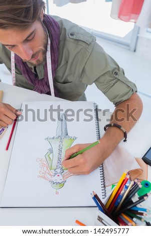 Fashion designer drawing a coat with pencils