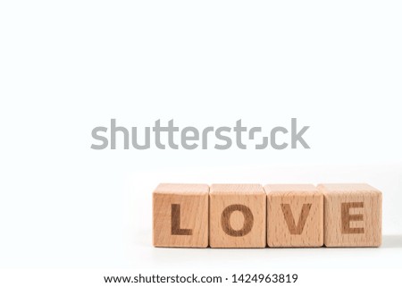 word LOVE on wood cube dices on white background.