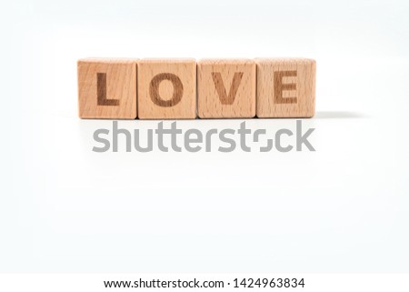 word LOVE on wood cube dices on white background.