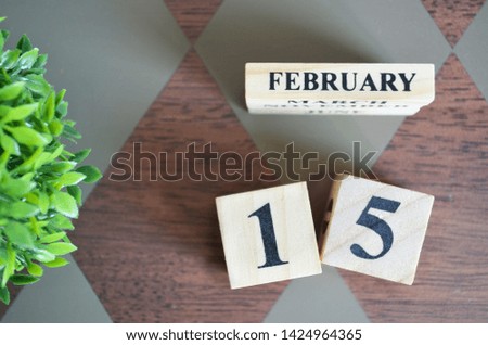 Date of February with leaf on diamond pattern table for background.