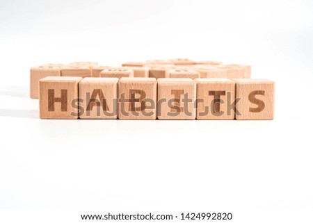 word HABITS on wood cube dices on white background.