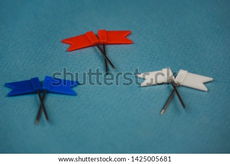 2 flags lying on top of each other in red blue and white on a blue background