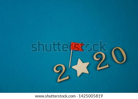 2020 number from wooden numbers on a blue background with scattered stars gears and flags around
