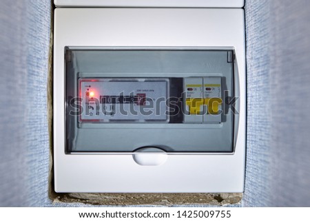 Electrical distribution box, distribution board with meter. Circuit breakers are switches which automatically trip open to interrupt the flow of electrical current when it overloads the circuit. Royalty-Free Stock Photo #1425009755