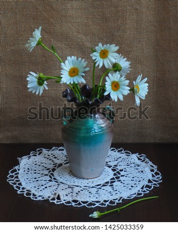 The photo was taken in 2019.The picture shows a vase with white daisies
