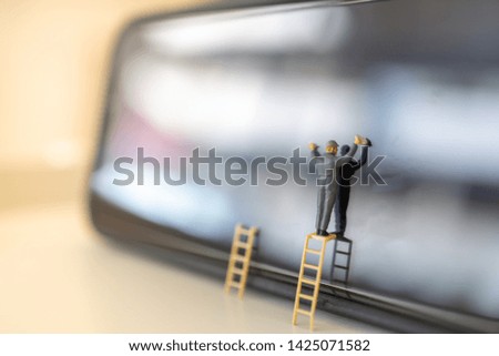 Communication and technology concept. Worker miniature figure stand on ladder to wipe and cleaning dirty smart phone glass screen.