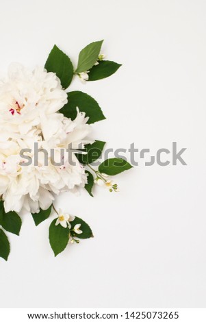 Beautiful peony flowers with green leaves and jasmine flowers frame on white background, top view, Spring summer concept. copy space. Flat Lay. Preparation for designer.