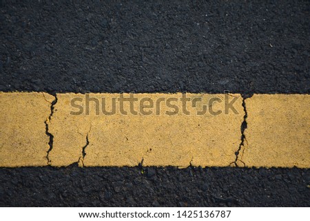 Surface rough of asphalt, Grey with yellow line on the road and small rock, Texture Background