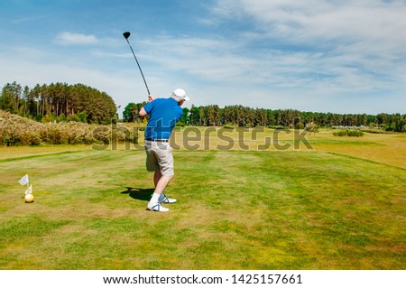 golf player on professional golf course. Golfer with golf club taking a shot