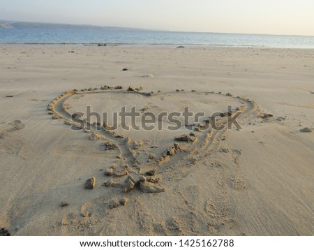 Close up view Hand writing on sand beach side with sign blank use design elemental nature. Summer spring day Form words alphabet typescript font written drawn carved note text. Spelled love shape will