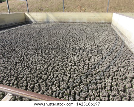 Sewage sludge,  is the remaining, semi-solid material that is left over after the cleaned-up water is discharged from a sewage treatment works. Royalty-Free Stock Photo #1425186197