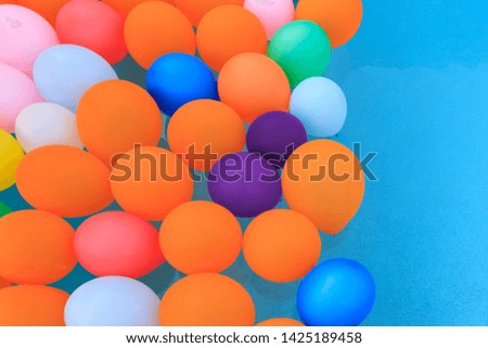 colorful balloons floating in backyard swimming pool