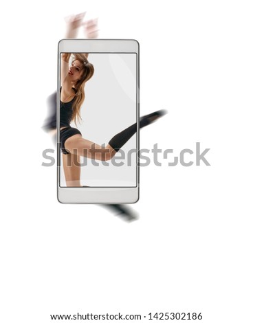 Portrait of beautiful young professional dancer on white background. conceptual image with a smartphone, demonstration of device capabilities