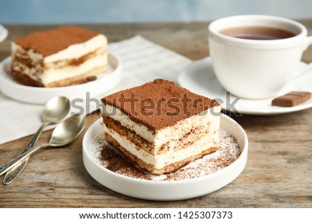 Composition with tiramisu cakes and tea on table Royalty-Free Stock Photo #1425307373