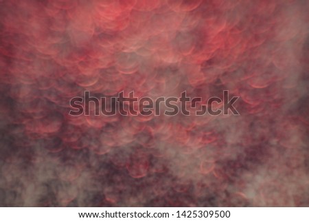 Beautiful red bokeh on a abstract smog background.