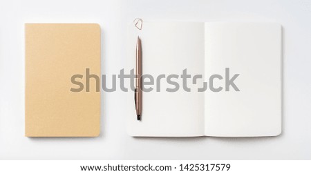 Design concept - Top view of hardcover kraft notebook and ballpoint pen isolated on white background for mockup