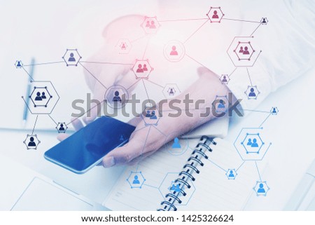 Businessman in white shirt working with smartphone at office table with double exposure of social network icons. Concept of social media and recruitment in business. Toned image blurred