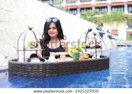 breakfast at the pool asian woman with summer bikini