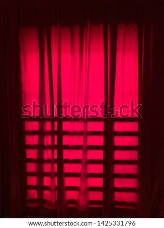 Red window curtain in a music hall