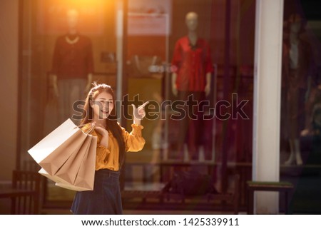 Asian Woman Holding Shopping BagsWoman in shopping. Happy woman with shopping bags enjoying in shopping